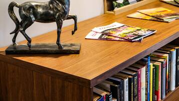 A wooden reception desk with a bronze horse sculpture, bookshelves with books, and a 'highlife' sign.