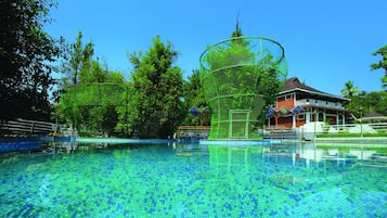Una piscina al aire libre, sombrillas, tumbonas
