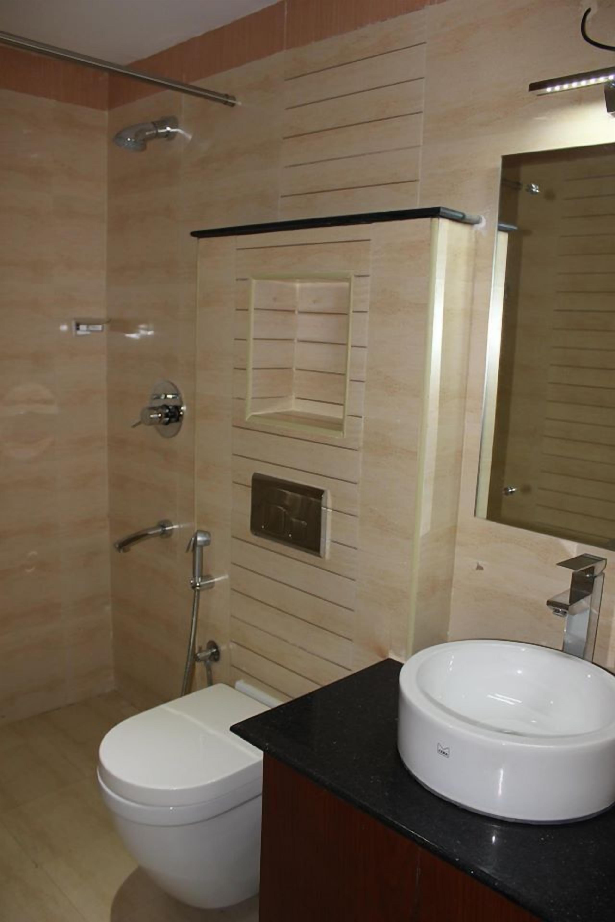 A bathroom with a toilet, a sink, a mirror, and a shower.