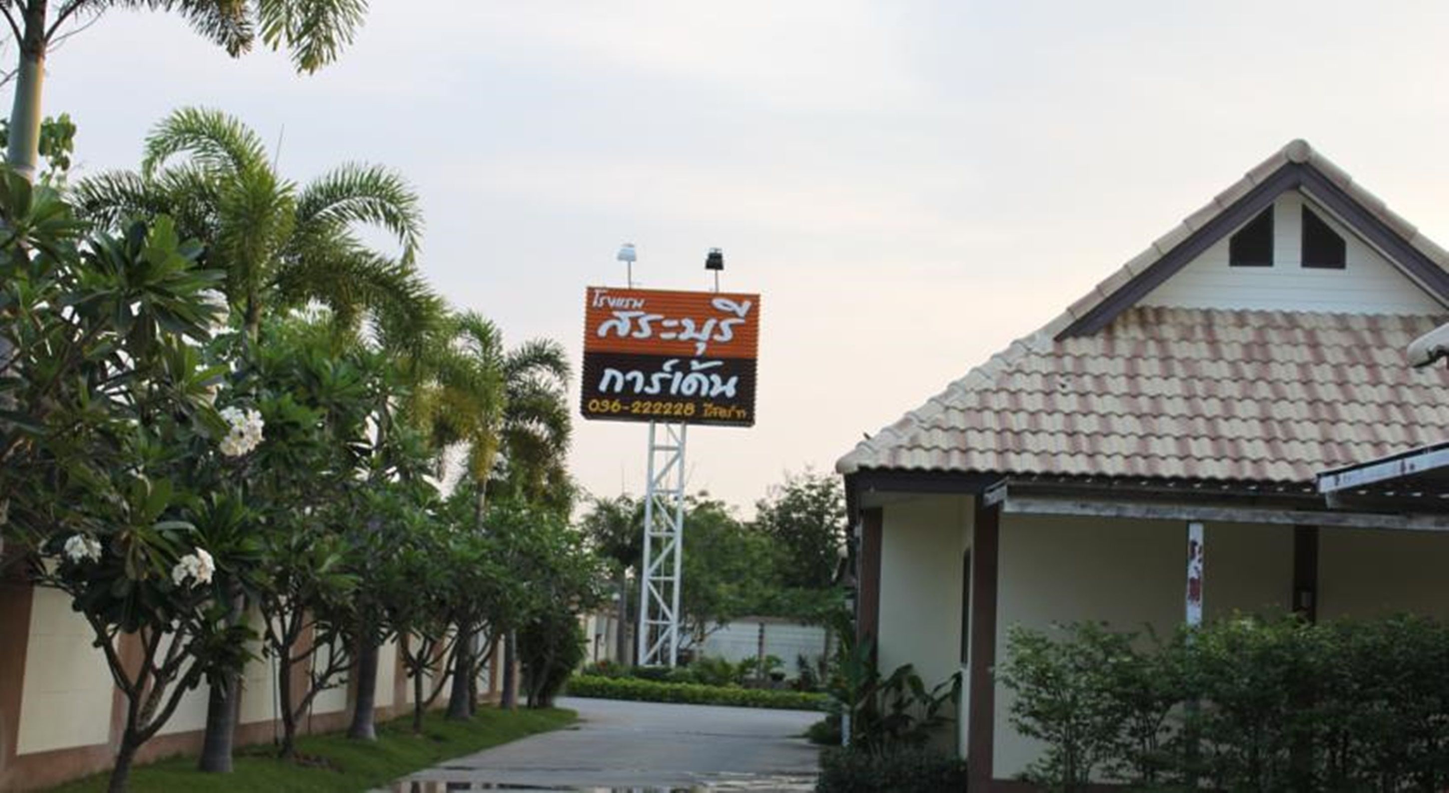A building with a tiled roof and a signboard with text in a non-Latin script.