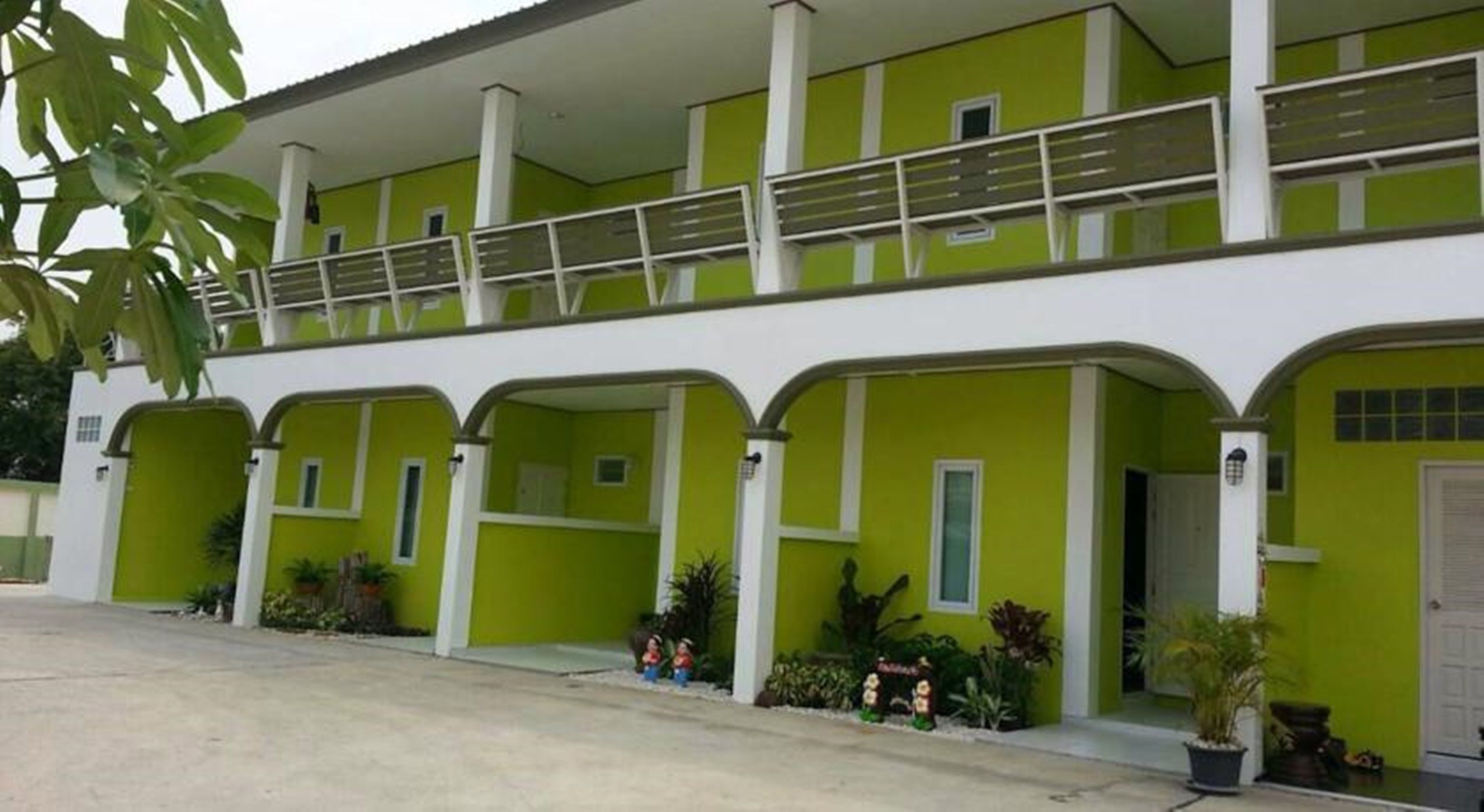 A two-story building with a green exterior and white trim.