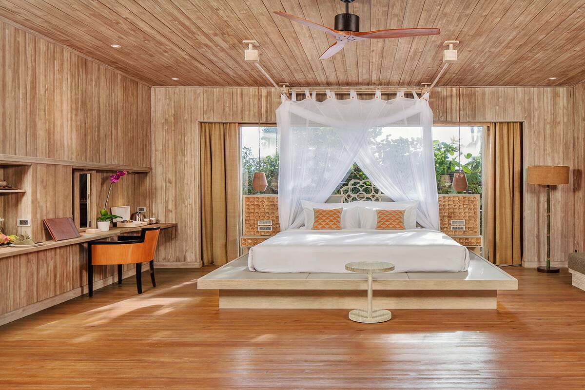 Ein geräumiges Schlafzimmer mit einem großen Bett, Nachttischen, einem Schreibtisch und einem Schlafsofa.