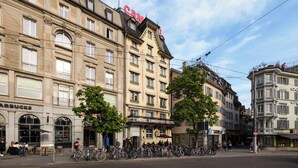 Un hotel con un letrero llamativo, varias ventanas y una fila de bicicletas estacionadas afuera.