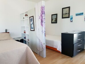 A bedroom with a bed, a desk, a wardrobe, and a dresser. There are pictures on the wall. - Knidos Hotel (Bodrum)