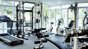 A gym with various exercise equipment, large windows, and a treadmill. - Baandara Resort Saraburi (Saraburi)