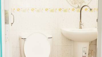A bathroom with a toilet, sink, and shower.