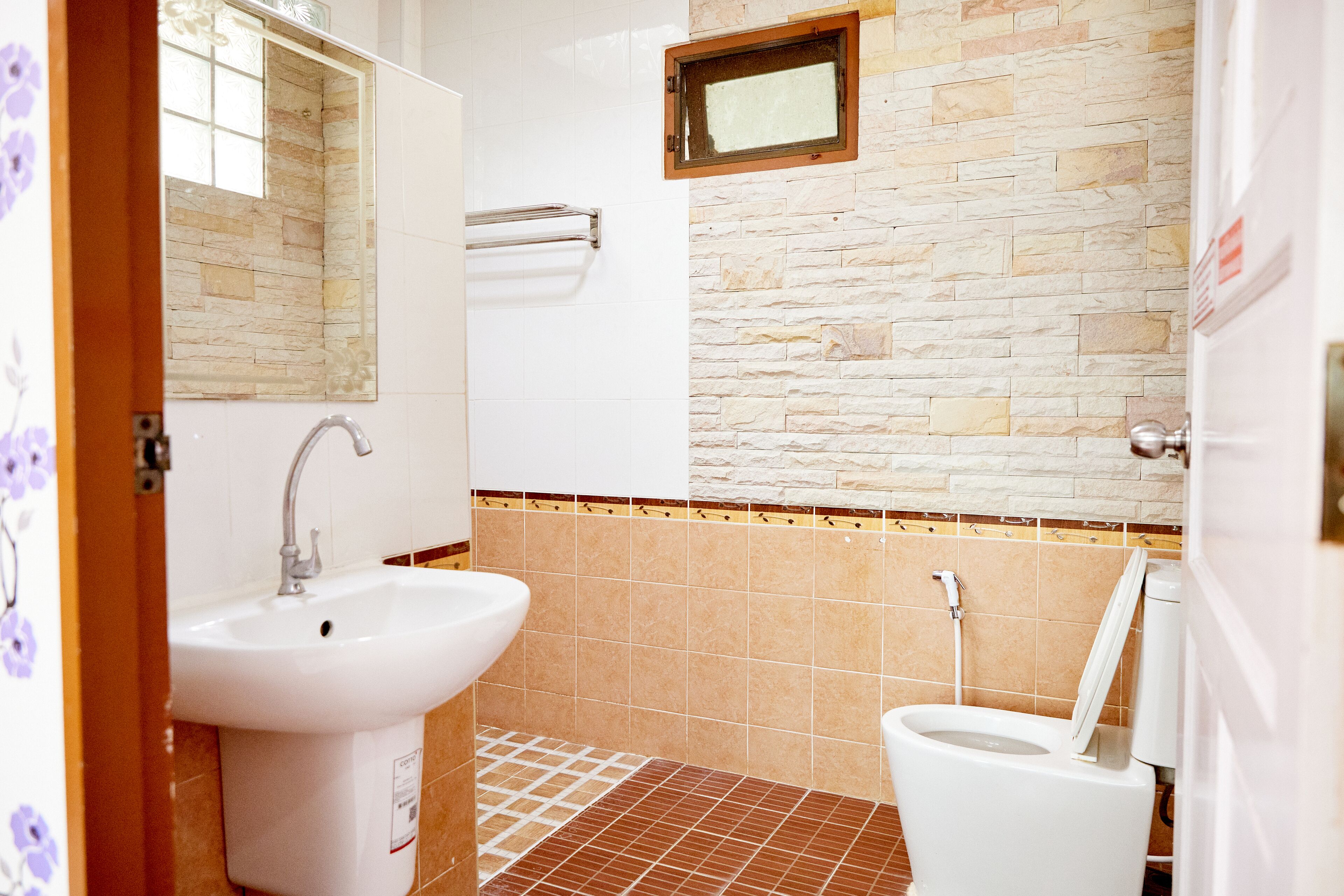 Ein Badezimmer mit Waschbecken, Toilette und Spiegel.
