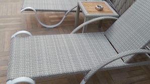 A row of grey wicker lounge chairs with wooden side tables, arranged on a wooden deck. - Lavinia Apart Hotel (Alanya)