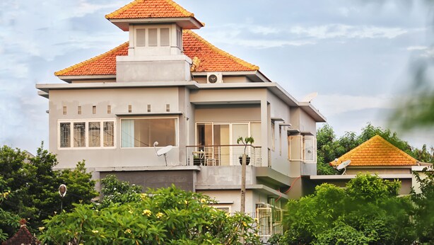 A modern two-story house with a sloped roof, satellite dishes, and a balcony. - DD Living - Hostel (Tibubeneng)