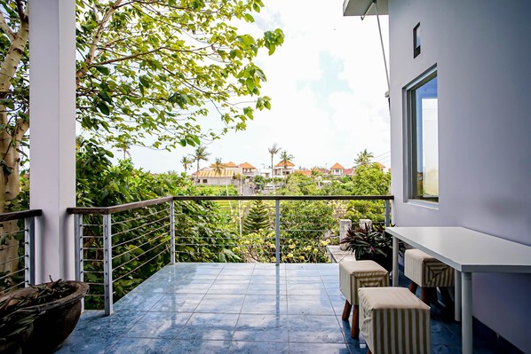 A balcony with a view of houses and greenery. - DD Living - Hostel (Tibubeneng)