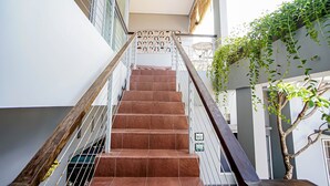 A staircase with wooden handrails and a metal railing, leading to an upper floor. - DD Living - Hostel (Tibubeneng)