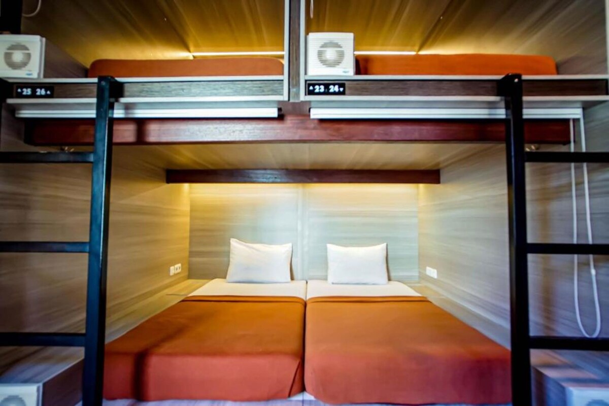 A bunk bed with two pillows and a wooden headboard.