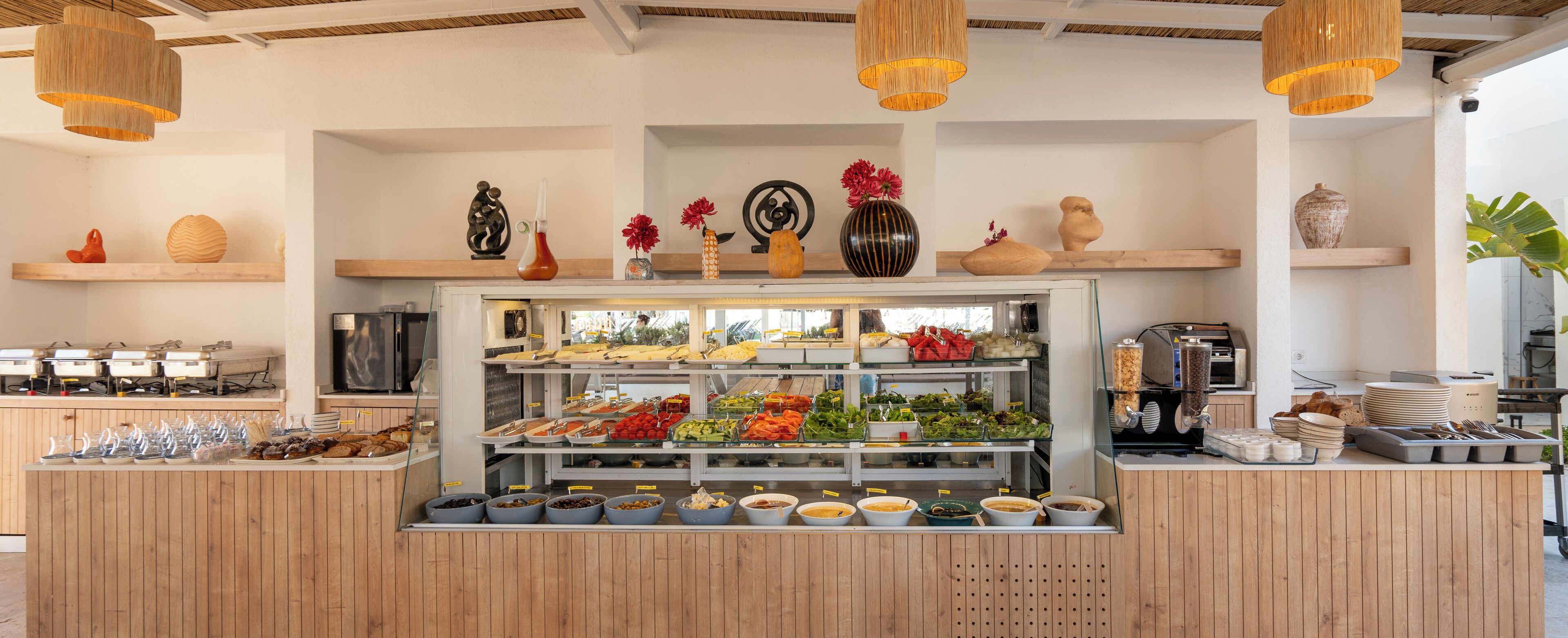 Zona de bufé con diferentes alimentos y estantes decorativos.