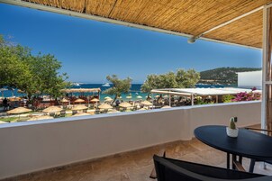 Una terraza con vistas al mar, mobiliario exterior y una mesa con un cactus.