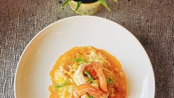 Un plato de comida con camarones y verduras sobre una superficie rugosa.