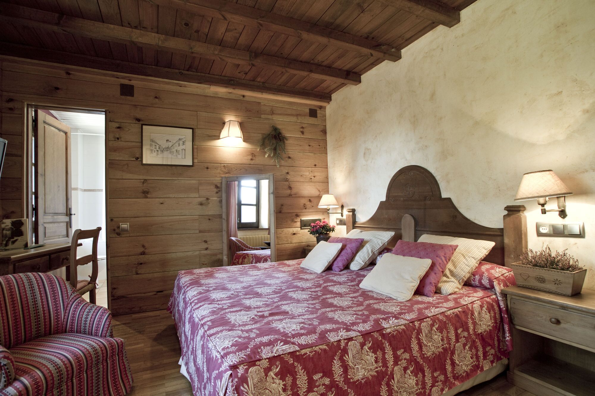 A wooden room with a bed, a chair, and a desk.
