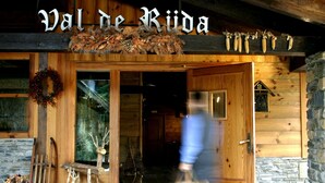 Entrada de un edificio de madera con un cartel que dice "Val de Ruda".