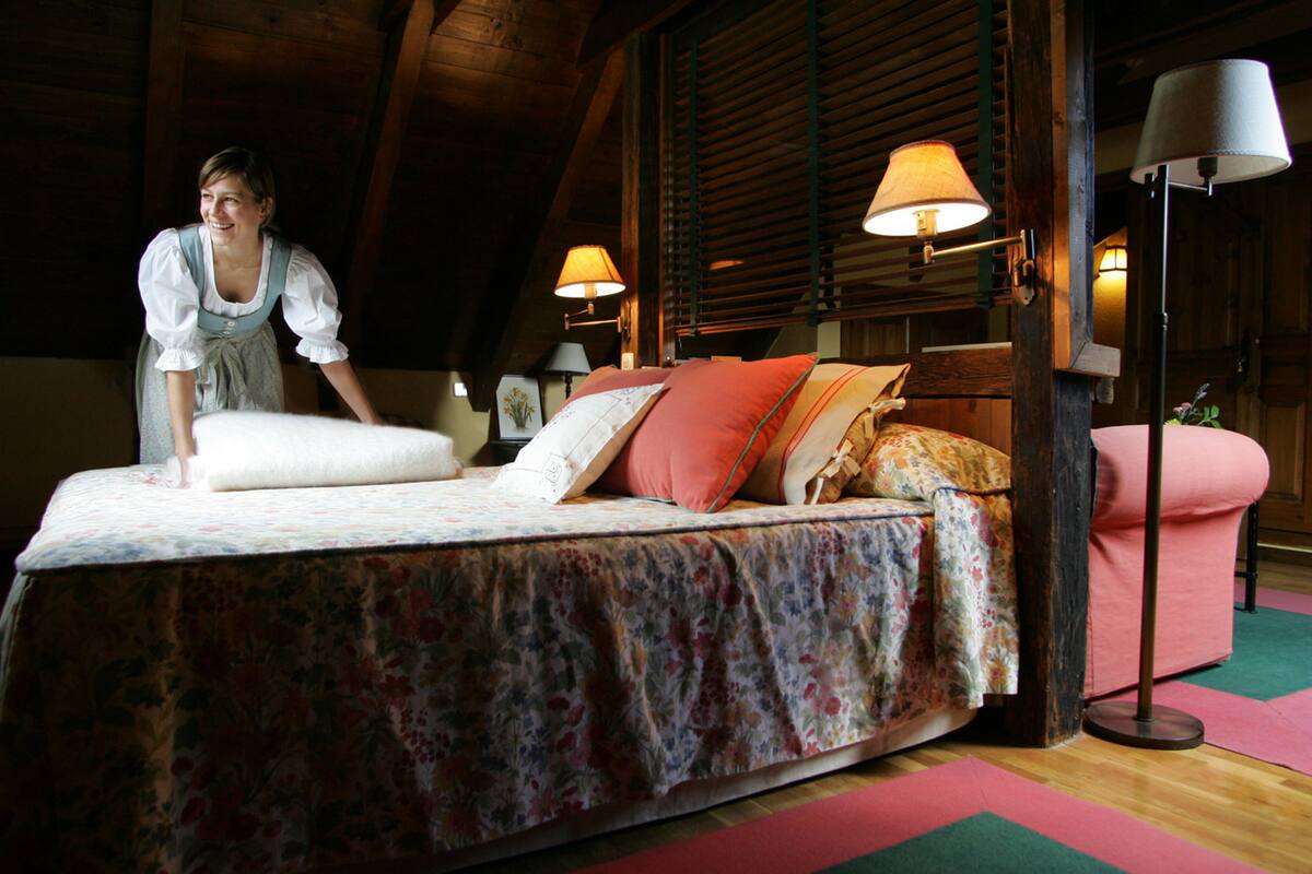 Ein Schlafzimmer mit einem Bett, Kissen, einem Nachttisch und einer Lampe.