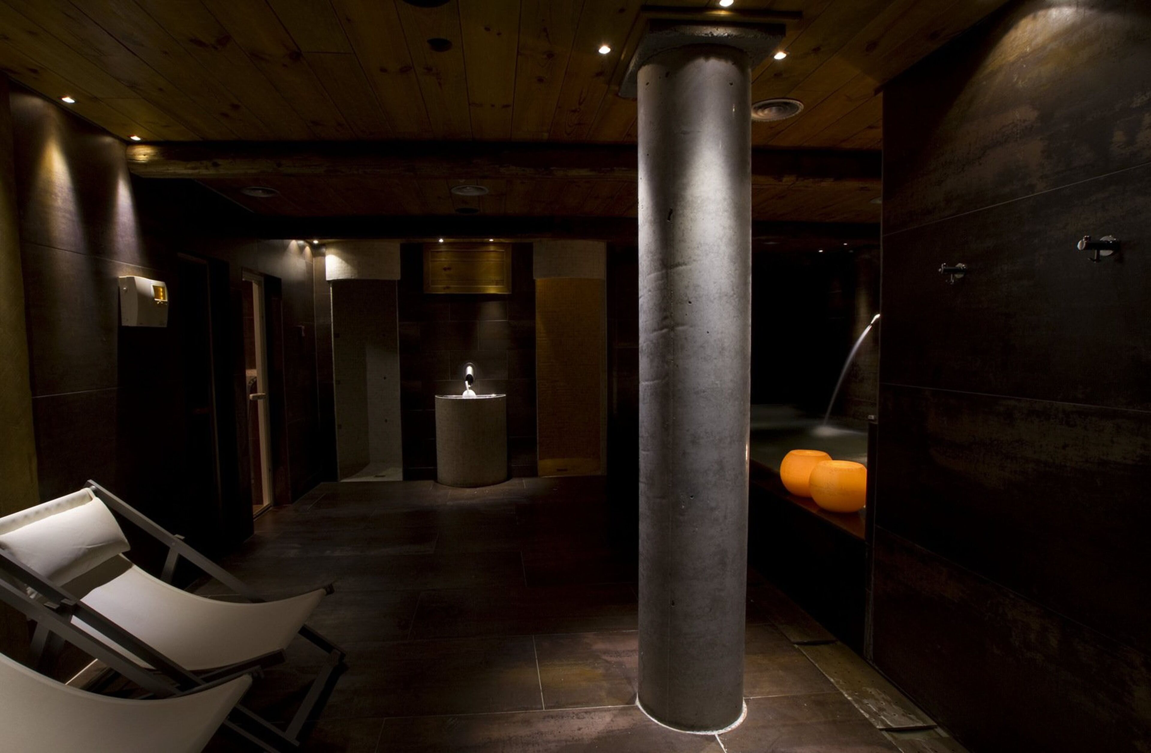 A modern interior with a large cylindrical column, a reception desk, and a minimalist design.