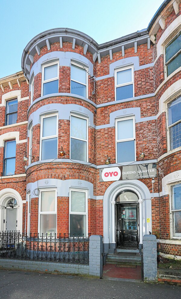A corner building with a sign reading "OYO Queens Quarter" at the entrance. - OYO Queens Quarter (Belfast)