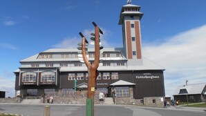 Un hôtel doté d’une tour imposante et de nombreux panneaux indiquant la présence d’installations telles qu’un restaurant et un bar.