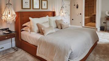 A spacious bedroom with a large bed, a bedside table, and a hanging light fixture.