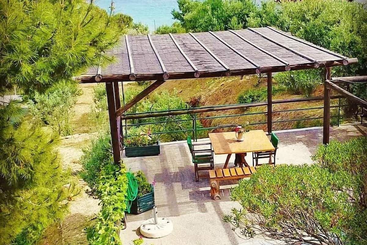 A patio area with a wooden pergola, a table, and chairs.