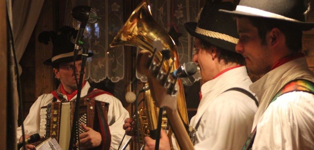 A group of musicians in traditional attire playing brass instruments.