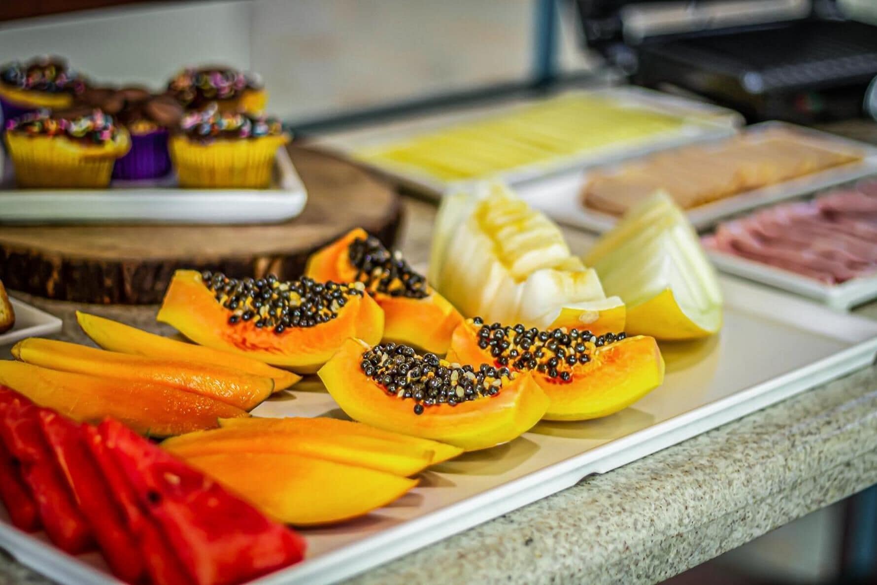 A buffet with various fruits and pastries.