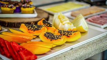 A buffet with various fruits and pastries.