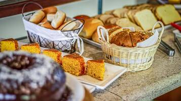 A buffet with various breads and cakes.
