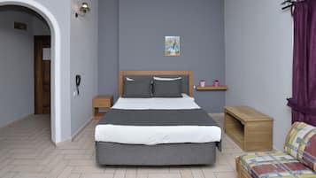 A bedroom with a bed, bedside tables, a nightstand, a wooden bench, a small shelf, a door, and a wall-mounted telephone.