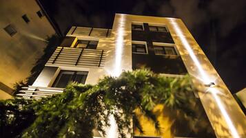 Un edificio moderno con fachada geométrica, múltiples ventanas y un balcón.