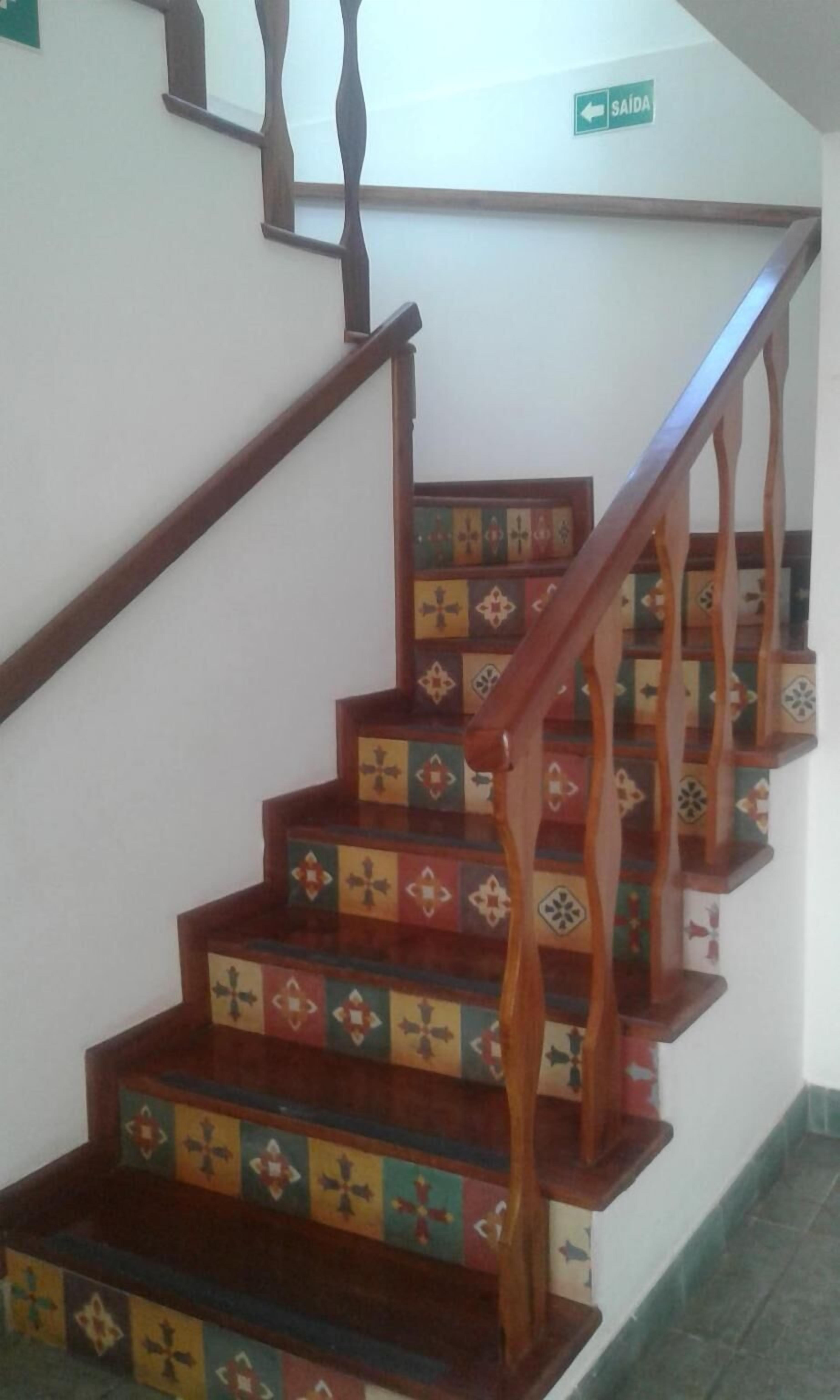 A staircase with wooden handrails and patterned steps.