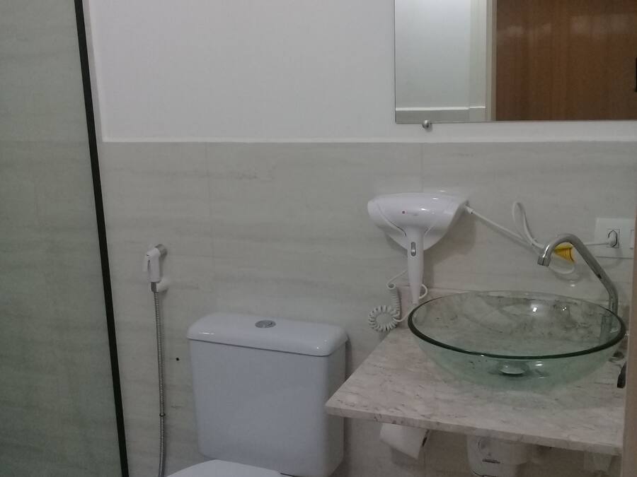 Une salle de bain avec des toilettes, un lavabo en verre et une douche.