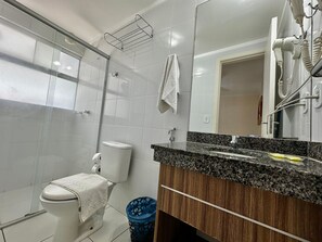 Un baño con inodoro, lavamanos, espejo y ducha.