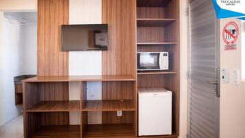 A kitchenette with wooden cabinetry, a microwave, and a refrigerator.
