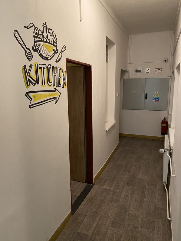 A hallway with a sign indicating the direction to the kitchen.