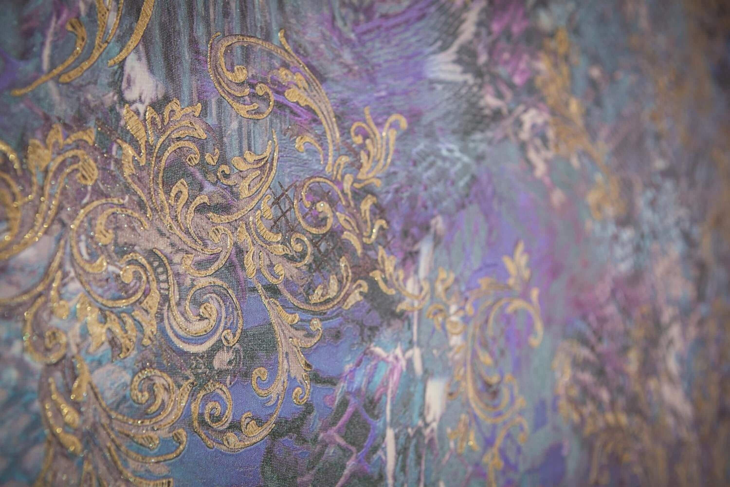 A close-up of a fabric with intricate golden embroidery.