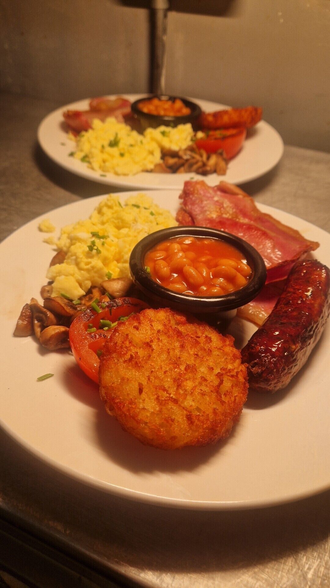 A plate of breakfast food including eggs, sausages, and beans.