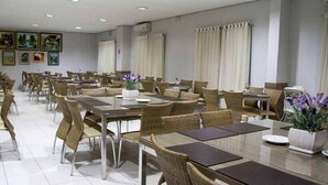 Un amplio comedor con múltiples mesas y sillas dispuestas en filas.