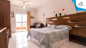 Un dormitorio con cama, escritorio, silla, armario y ventilador de techo.
