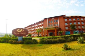 A multi-story hotel with a prominent entrance and a well-maintained lawn area.
