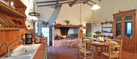 Une cuisine rustique avec une cheminée, des meubles en bois et un coin repas.