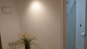 A dining area with a table, chairs, a pendant light, and a potted plant. - Gorbea Suites (Monachil)