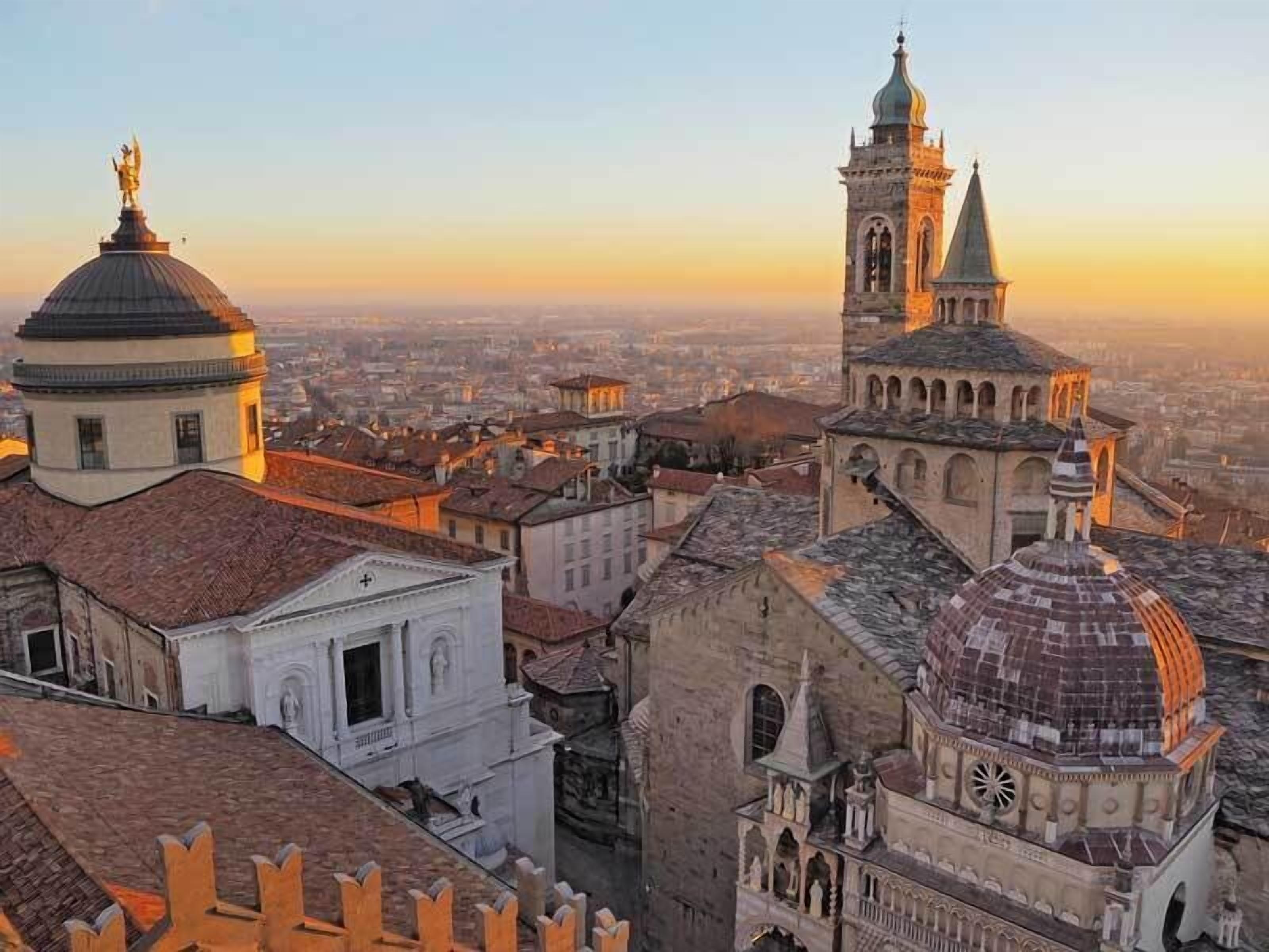 A cityscape with historic architecture, including domed buildings and a tower with a spire.