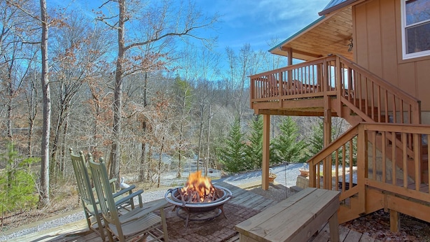 A wooden deck with a fire pit, benches, and a staircase leading to a balcony. - Gettin Cozy (Sevierville)
