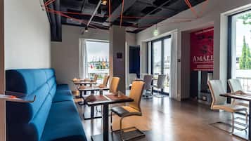 L'intérieur d'un restaurant moderne, avec un canapé bleu, des tables et des chaises.