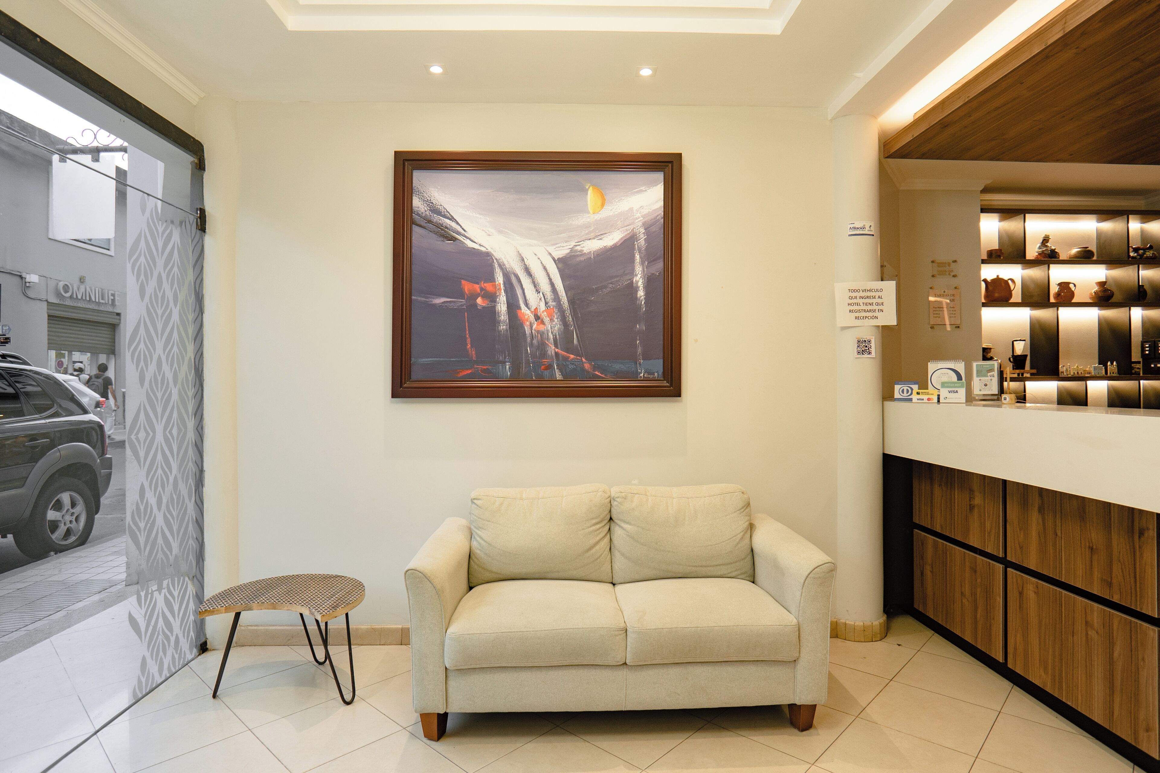 A modern interior with a sofa, a framed painting, and a bar area.