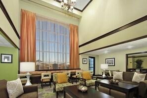 A hotel lobby with a large window, seating area, and a chandelier. - Staybridge Suites Odessa - Interstate HWY 20 by IHG (Odessa)